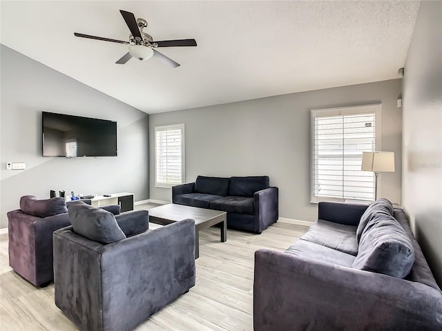 living room with light wood-type flooring, lofted ceiling, baseboards, and ceiling fan