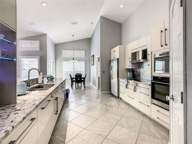 kitchen with extractor fan, decorative light fixtures, stainless steel appliances, high vaulted ceiling, and a sink