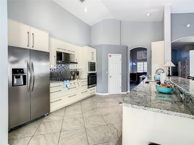 kitchen with stainless steel fridge with ice dispenser, backsplash, kitchen peninsula, and light stone countertops