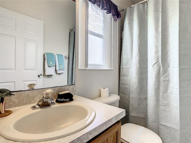 bathroom with a shower with curtain, toilet, and vanity