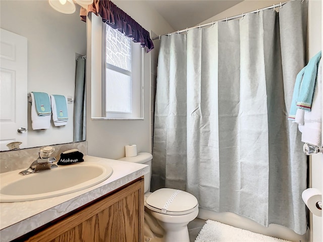 bathroom featuring shower / bath combo with shower curtain, toilet, and vanity