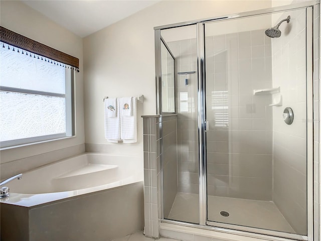 bathroom featuring a garden tub and a shower stall