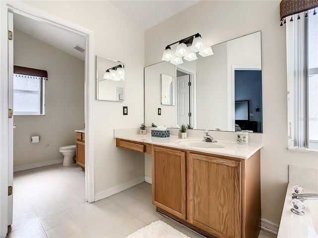 bathroom featuring vanity, a healthy amount of sunlight, and tile patterned floors