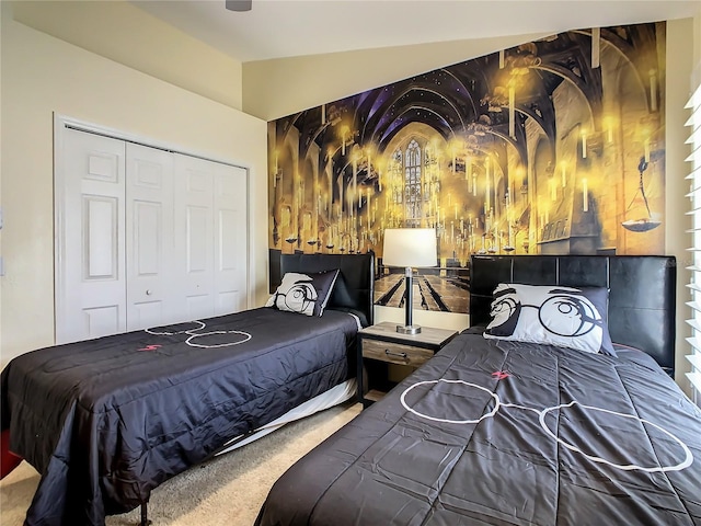 bedroom with a closet, lofted ceiling, and carpet flooring