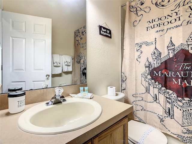 bathroom with curtained shower, toilet, and vanity