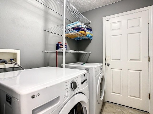 washroom featuring separate washer and dryer and a textured ceiling