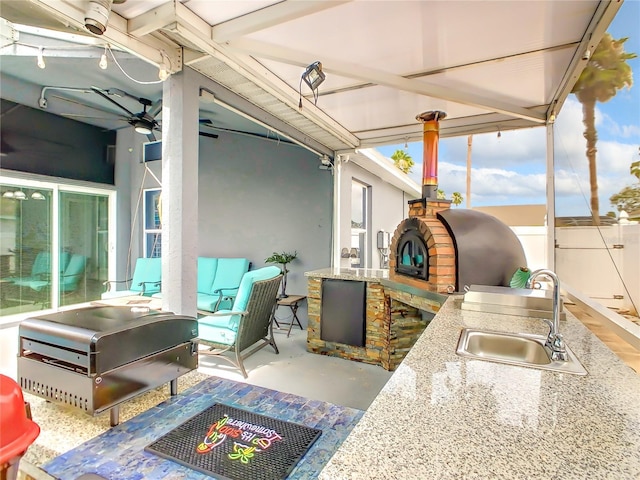 view of patio / terrace with an outdoor hangout area, exterior kitchen, ceiling fan, and a sink