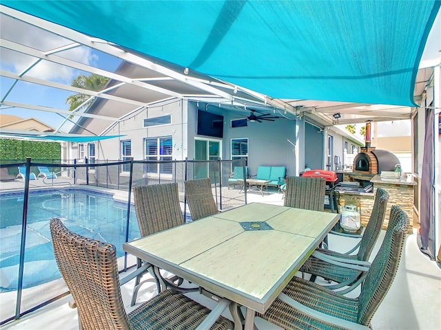 view of patio with an outdoor pool, area for grilling, outdoor dining space, and a ceiling fan