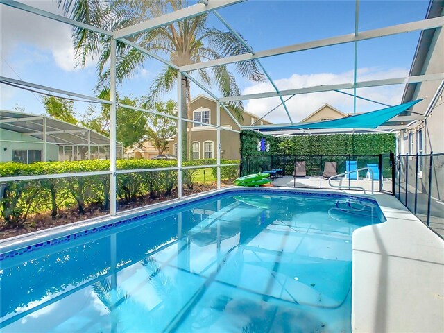 view of swimming pool featuring a lanai and a patio