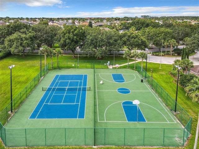 view of sport court with a lawn, community basketball court, and fence