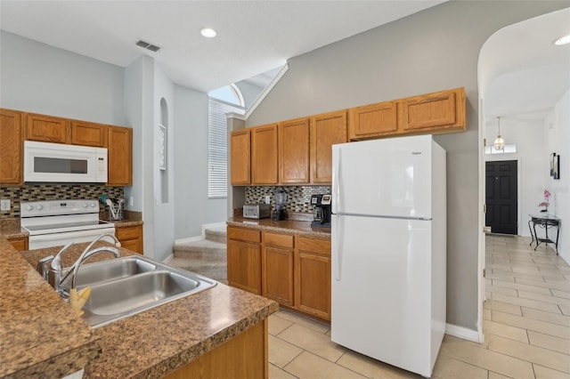 kitchen featuring hanging light fixtures, white appliances, sink, light tile patterned flooring, and tasteful backsplash