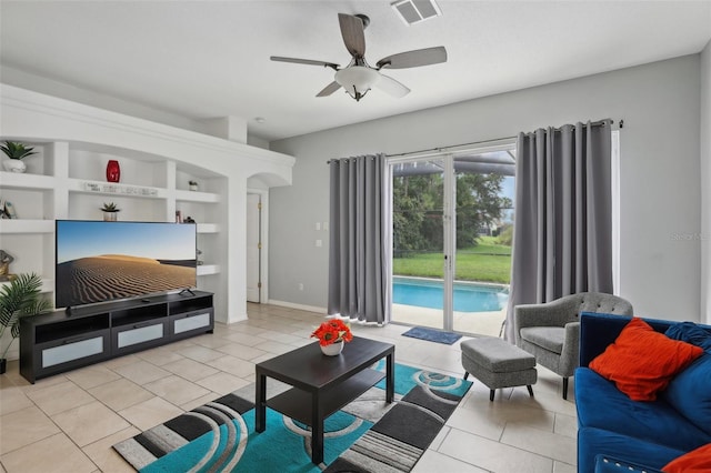 living room featuring built in features, light tile patterned floors, and ceiling fan