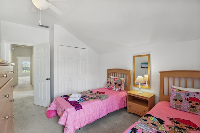 carpeted bedroom with vaulted ceiling, ceiling fan, and a closet