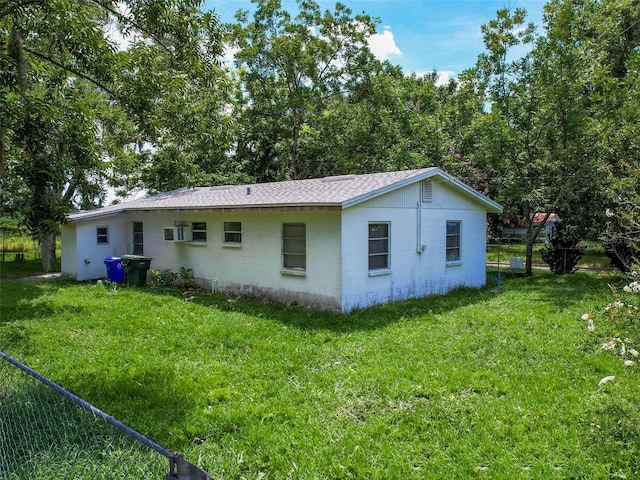 rear view of property with a lawn and a wall mounted air conditioner