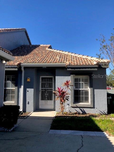 doorway to property featuring a tiled roof and stucco siding