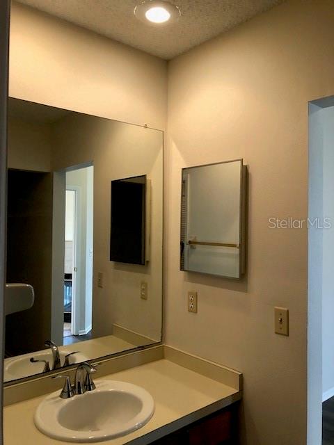 bathroom featuring a textured ceiling and vanity