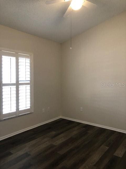 unfurnished room featuring ceiling fan and dark hardwood / wood-style floors