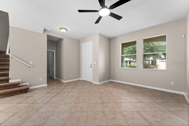 10617 Bamboo Rod Cir, Riverview, FL 33569 - spare room with ceiling fan, stairway, light tile patterned floors, and baseboards