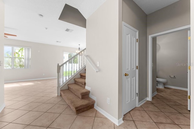 10617 Bamboo Rod Cir, Riverview, FL 33569 - staircase featuring plenty of natural light, tile patterned flooring, and baseboards