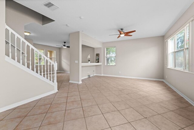10617 Bamboo Rod Cir, Riverview, FL 33569 - unfurnished living room featuring ceiling fan, stairs, light tile patterned flooring, and baseboards