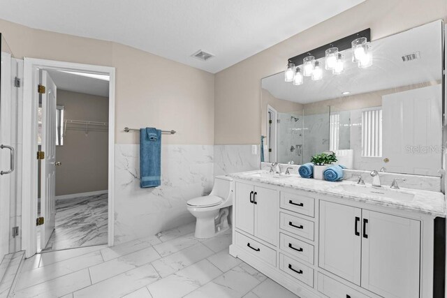 10617 Bamboo Rod Cir, Riverview, FL 33569 - full bathroom with marble look tile flooring, a stall shower, tile walls, wainscoting, and a walk in closet
