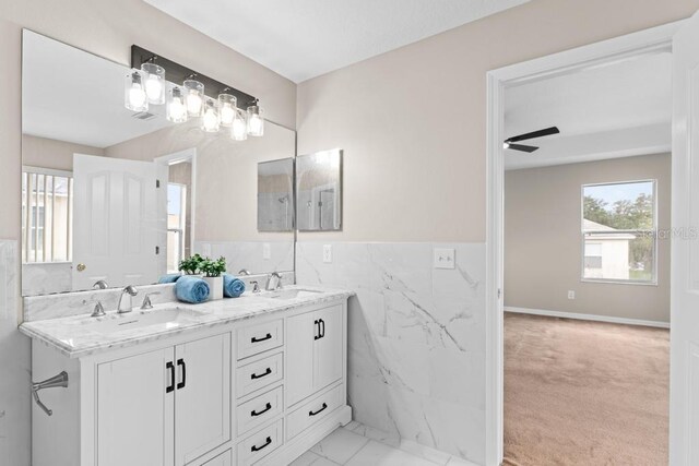 10617 Bamboo Rod Cir, Riverview, FL 33569 - bathroom featuring tile walls, double vanity, a wainscoted wall, a ceiling fan, and marble look tile flooring