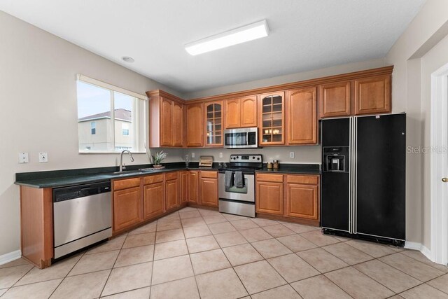 10617 Bamboo Rod Cir, Riverview, FL 33569 - kitchen featuring appliances with stainless steel finishes, a sink, brown cabinets, and dark countertops