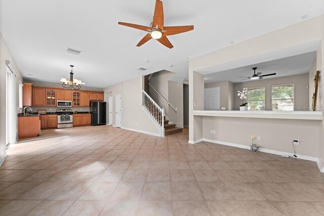 10617 Bamboo Rod Cir, Riverview, FL 33569 - unfurnished living room featuring a chandelier, stairs, a ceiling fan, light tile patterned floors, and a sink