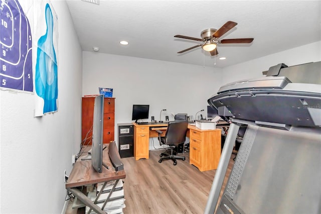 home office with light wood-type flooring and ceiling fan