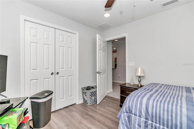 bedroom featuring light hardwood / wood-style flooring, ceiling fan, and a closet