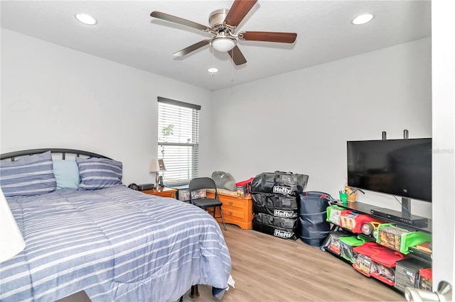 bedroom with light hardwood / wood-style flooring and ceiling fan