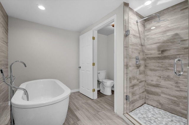 bathroom with a stall shower, baseboards, a freestanding bath, and toilet