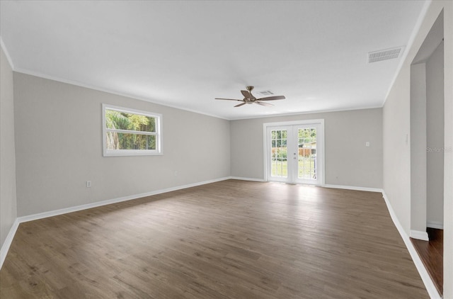 empty room with visible vents, baseboards, french doors, dark wood-style floors, and crown molding