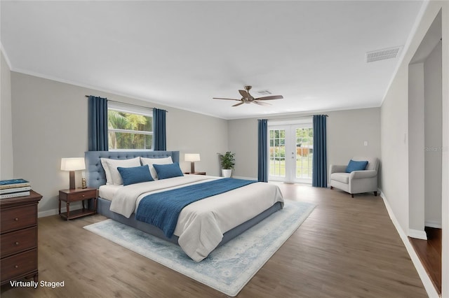 bedroom featuring visible vents, baseboards, wood finished floors, access to exterior, and crown molding