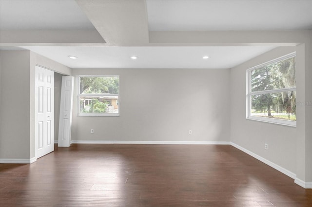 unfurnished room with dark wood-style flooring, recessed lighting, a wealth of natural light, and baseboards