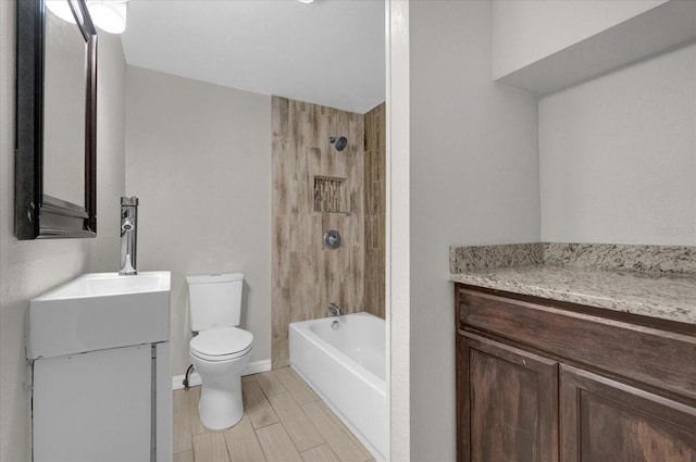 bathroom featuring baseboards, toilet, wood tiled floor, bathtub / shower combination, and vanity