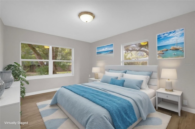 bedroom with baseboards and wood finished floors