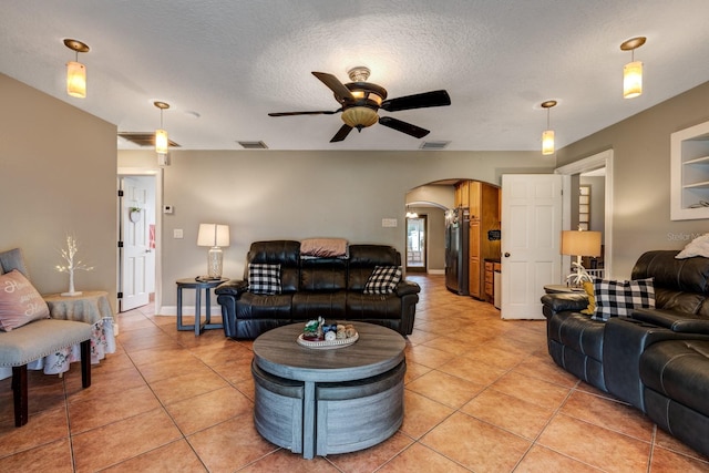 tiled living room featuring a textured ceiling and ceiling fan