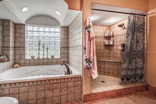 bathroom with tile patterned flooring, independent shower and bath, and a textured ceiling