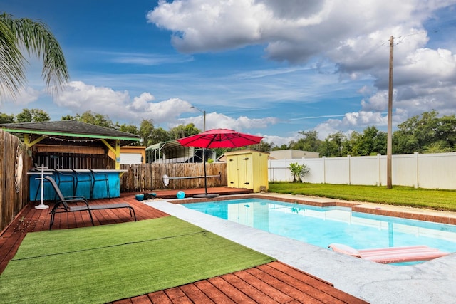 view of pool featuring a storage unit and a wooden deck