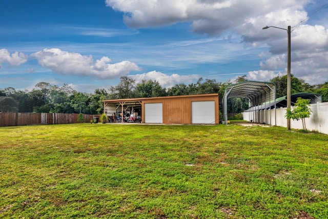 view of yard with an outdoor structure, a garage, and a carport