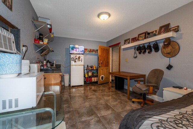 bedroom featuring dark tile patterned flooring and white fridge