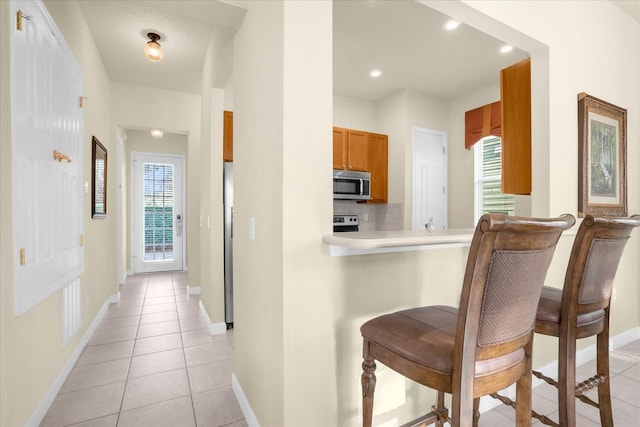 kitchen with backsplash, plenty of natural light, range, and light tile patterned floors