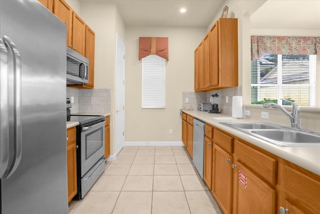 kitchen featuring sink, stainless steel appliances, light tile patterned floors, and tasteful backsplash