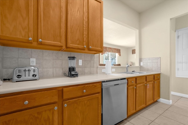 kitchen with light tile patterned floors, backsplash, sink, and dishwasher