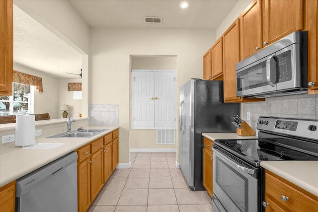 kitchen featuring sink, tasteful backsplash, appliances with stainless steel finishes, and light tile patterned flooring