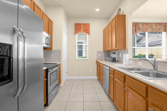 kitchen with a wealth of natural light, sink, stainless steel appliances, and decorative backsplash