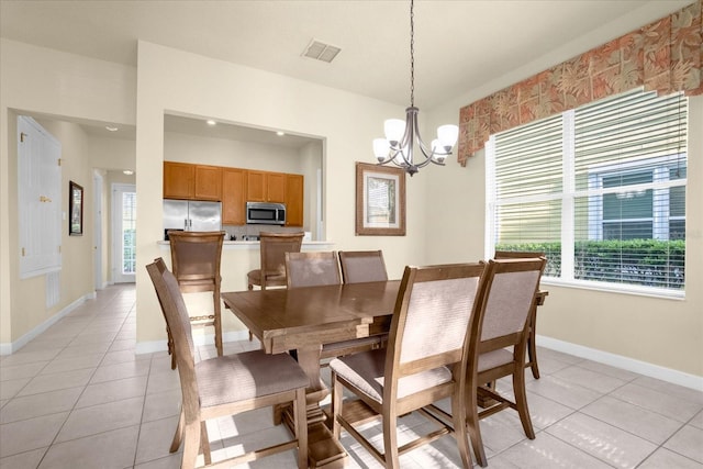 dining area with a healthy amount of sunlight, light tile patterned floors, and an inviting chandelier