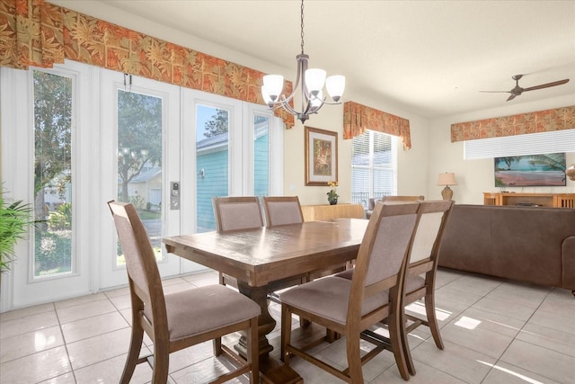 dining room with light tile patterned floors, ceiling fan with notable chandelier, and plenty of natural light