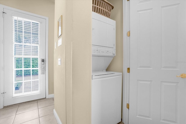 laundry room featuring light tile patterned floors and stacked washing maching and dryer